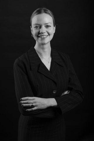 Authentisches Businessportrait einer Frau mit dezentem Lächeln vor schwarzem Hintergrund – Bewerbungsfoto in Kiel
