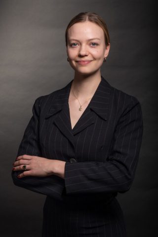 Studioaufnahme für eine Bewerbung – Frau im schlichten Business-Outfit vor dunklem Hintergrund