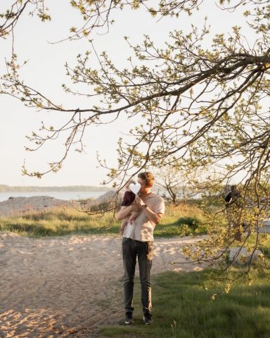 Vater hält sein Baby liebevoll im Arm – Familienfotoshooting am Strand in Kiel bei Abendlicht