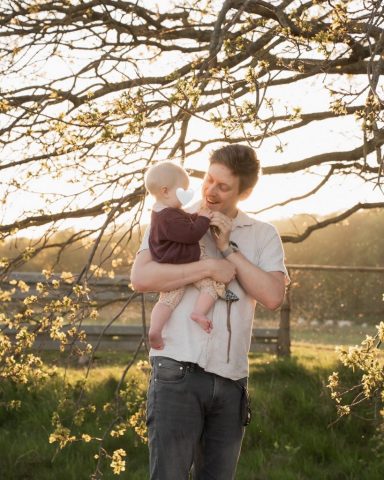 Inniger Moment zwischen Vater und Baby beim Familienfotoshooting am Kieler Strand im warmen Licht des Sonnenuntergangs