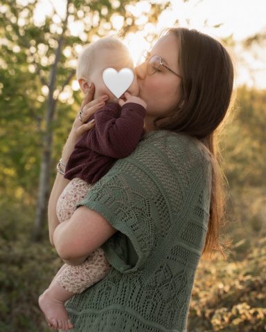 Mutter küsst liebevoll ihre Babytochter im warmen Gegenlicht – Familienfotoshooting in Kiel am Abend