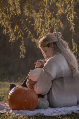 Inniger Moment in Kiel: Mutter und ihre kleine Tochter am See, aufgenommen von hinten in ruhiger, natürlicher Umgebung