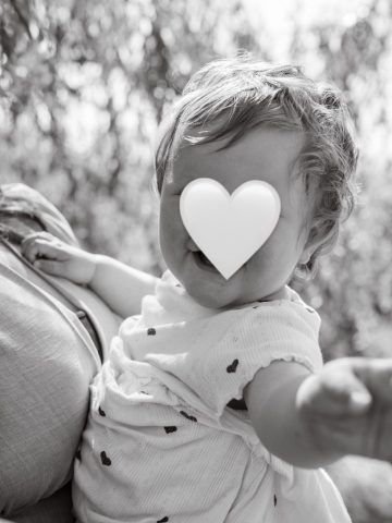 Stimmungsvolles Portrait des kleinen Mädchens auf dem Arm ihrer Mutter im Park in Kiel – Familienfoto im natürlichen Licht