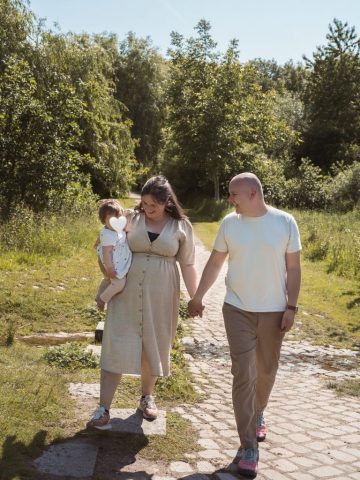 Kleines Mädchen mit ihren Eltern im Grünen – natürliches Fotoshooting zum 1. Geburtstag in Kiel