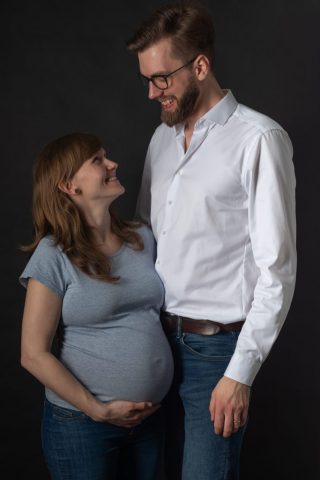 Stimmungsvolles Studiofoto eines Paares, das sich mit einem warmen Lächeln anschaut